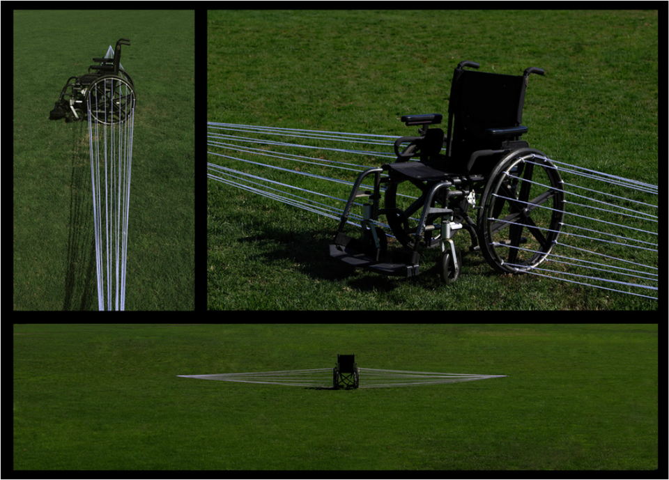A wheelchair on grass, strung with taut white lines