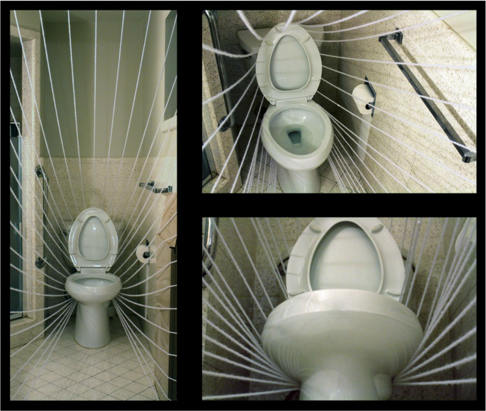 A porcelain toilet strung to the bathroom walls with radiating white lines