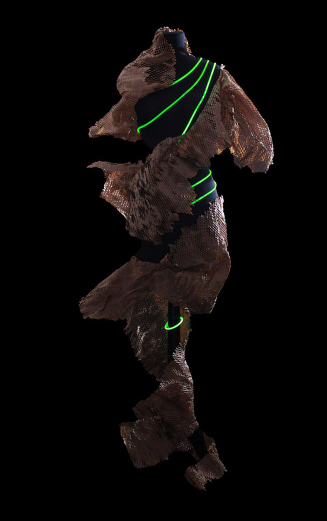 A garment sculpture wrapped in glowing green EL wire